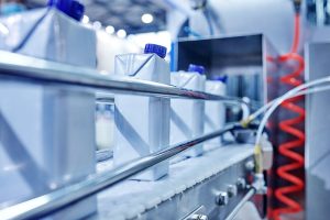 Cartons for liquid move along a conveyor belt