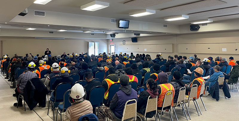 More than 100 Cargill Watson members seated in rows of chairs in a large meeting space facing a head table where someone is speaking.