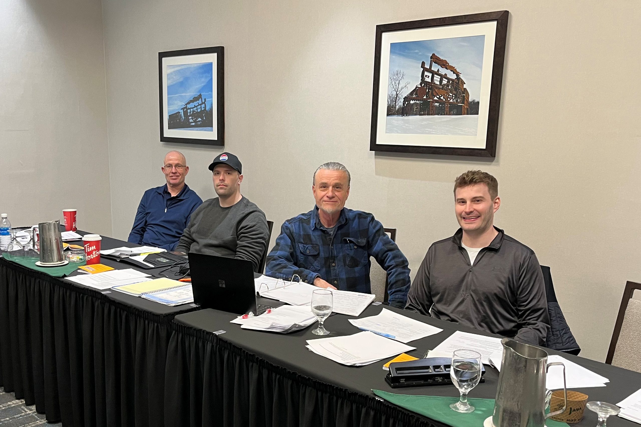 Four negotiation committee members sit at a table for a group shot.