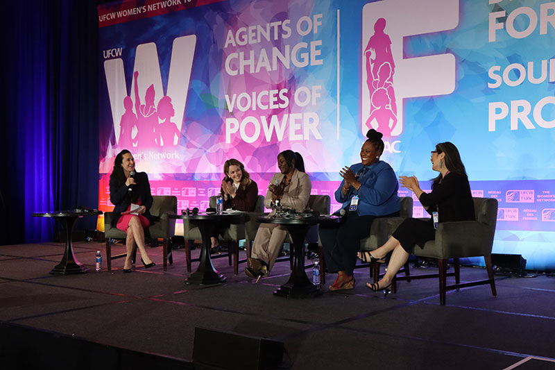 4 panelists sit on chairs on stage