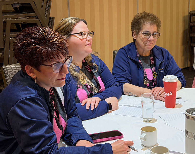 3 delegates seated at a table during a workshop