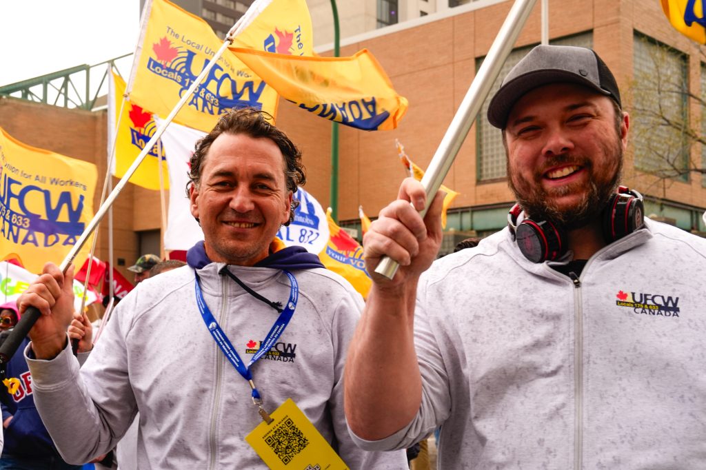 2 UFCW delegates smile during a rally