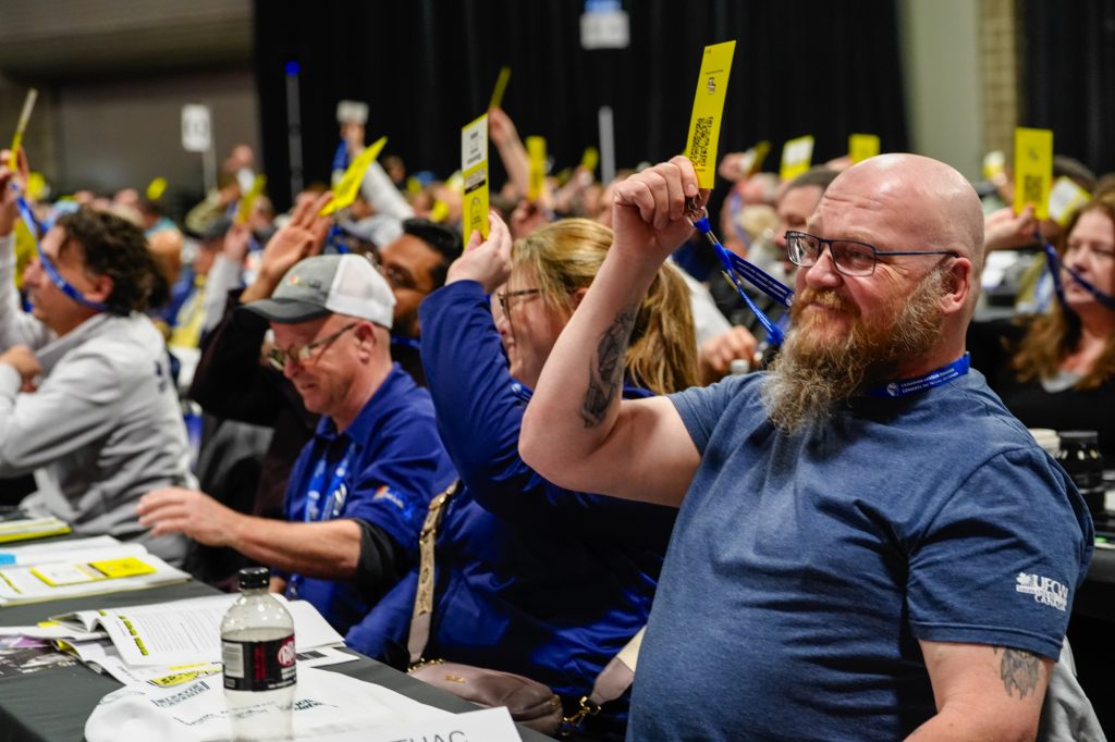 UFCW delegates vote during the 2026 CLC Convention by raising their badges