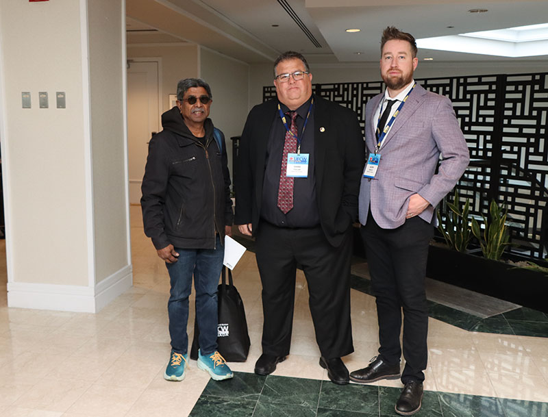 Executive Assistant Chris Fuller and Regional Director Jason Hanley stand next to a union steward who has a UFCW tote bag