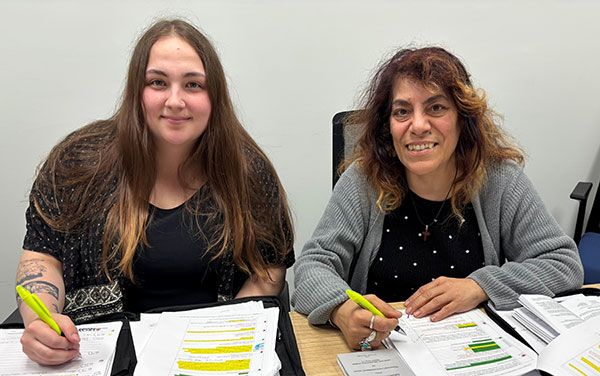 Marissa Speek-Jiampa and Franca Johnston seated at a table with paperwork - Carmody's YIG