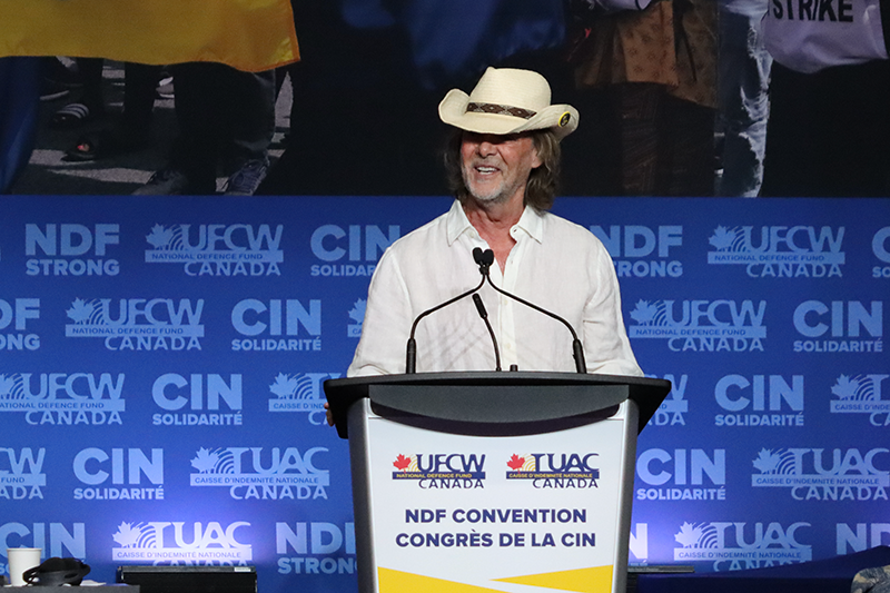 UFCW Local 401 President Tom Hesse wears a cowboy hat while speaking from the podium
