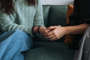 A healthcare worker holds a patient's hand.