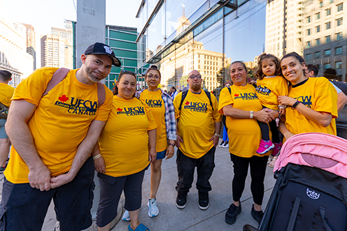 6 adults and a child all sporting ufcw yellow shirts as they wait for the toronto parade to begin