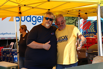 2 people in UFCW shirts pose together next to the bbq in Cornwall
