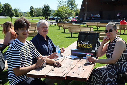3 people seated at a picnic table in Cornwall