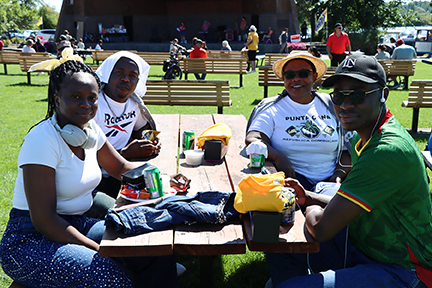 4 people seated at a picnic table with ufcw shirts and other items on the table top in cornwall