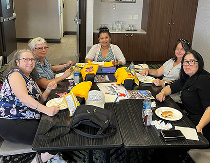 5 people seated at a table with food and UFCW shirts in North Bay