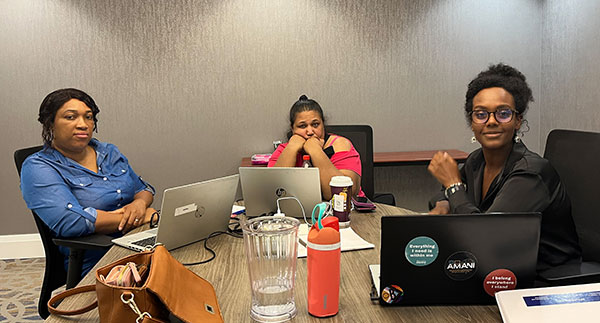 3 people from Rexdale Community Health Union Negotiating Committee seated around a table with their laptop computers open